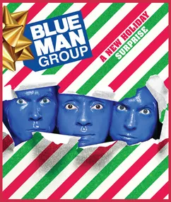 Three men, fully painted in blue, burst through red/white/green striped wrapping paper.